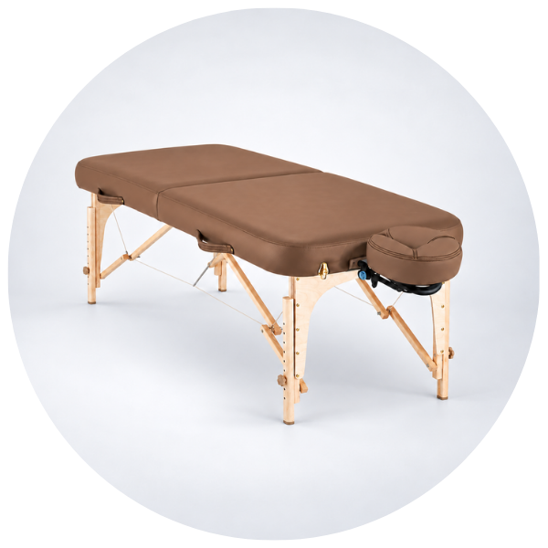 A folding massage table with a brown padded top and light natural wood legs, shown on a clean white background inside a circular frame.