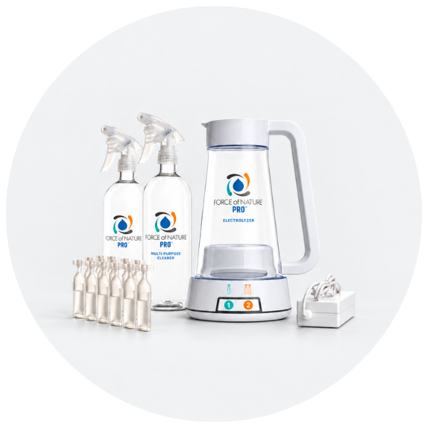 Force of Nature Pro multi-purpose cleaner kit including a glass electric kettle, two spray bottles, several small ampoules, and a charging dock, arranged on a light gray background.