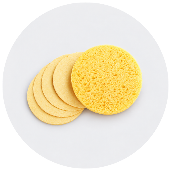 Four round yellow makeup sponges, with one sponge standing upright in front of a fan of four others, set against a light gray circular background.
